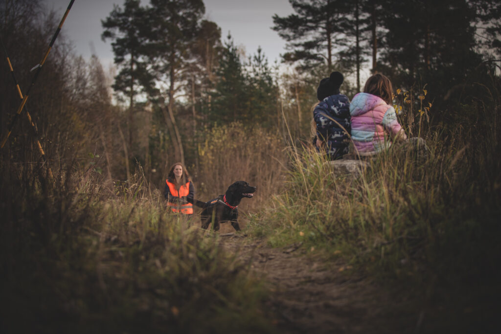 En hund har letat upp två vilsna barn som sitter på en stubbe.